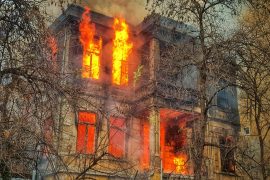 photo of burning house near trees