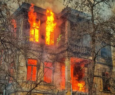 photo of burning house near trees