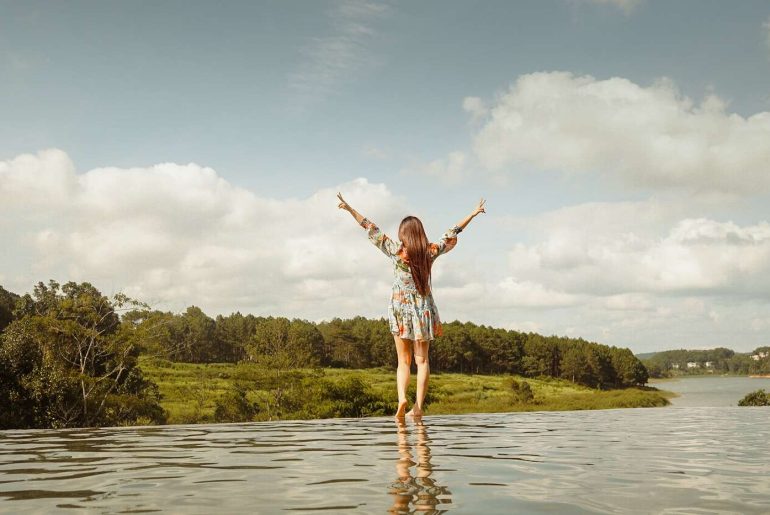 woman in red and white plaid shirt and white shorts standing on water during daytime