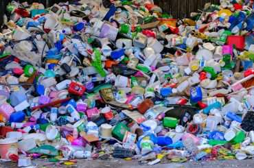 A pile of plastic bottles sitting on top of a street