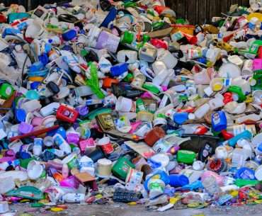 A pile of plastic bottles sitting on top of a street